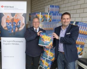 Christian Heinz von der HFUK Nord (rechts) übergab die ersten Spiele an den schleswig-holsteinischen Landesjugendfeuerwehrwart Dirk Tschechne. Das Spiel "112-Sicher dabei!" wird an die Jugend- und Kinderfeuerwehren im Geschäftsgebiet der HFUK Nord kostenlos verteilt.