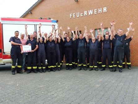 Die FF Bröthen ließ ihrer Freude bei der Übergabe des Fitnessgutscheins freien Lauf. (Foto: HFUK Nord / Mohr)