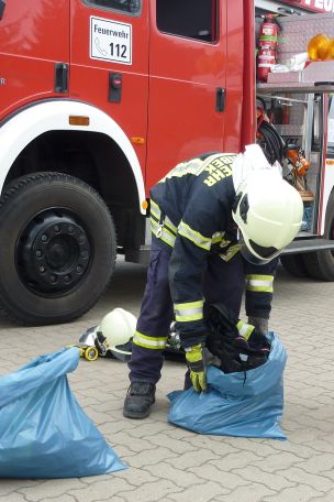 Einsatzhygiene ist Gesundheitsschutz! Das Bild zeigt eine Einsatzkraft beim Ablegen verschmutzter PSA. (Bild: Dirk Rixen / HFUK Nord)