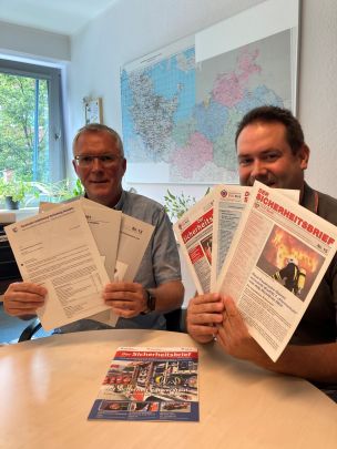 Jürgen Kalweit (links) und Christian Heinz vom Redaktionsteam "Der Sicherheitsbrief" haben alte Ausgaben der Infoschrift aus dem Archiv geholt. (Bild: Sonja Ruge / HFUK Nord)