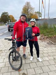 Partnerschaftliches Zusammenkommen nahe der Holtenauer Hochbrücke: Jürgen Kock (LFV S-H) übergibt den Laufrucksack an Katja Wormuth (FF Altenholz und HFUK Nord). (Bild: Mareike Dahms / LFV S-H)