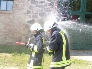 Einen Feuerwehrhelm mit dem Wasserstrahl vom Kopf schießen, kann gefährliche Verletzungen zur Folge haben. (Bild: Jürgen Kalweit/HFUK Nord)
