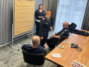 Die Landesfeuerwehrärztin Dr. Bunke mit fachlichen Erläuterungen beim Messen der Herzfrequenz und des Blutdrucks (Bild: Christian Heinz / HFUK Nord)