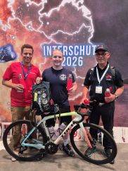 Der Referent für Gesundheitliche Prävention der HFUK Nord Jens-Oliver Mohr, Niclas Schuldt aus der Feuerwehr Hannover und Landessportreferent Oliver Moravec (LFV Niedersachsen) (v.l.n.r.) nehmen auf der INTERSCHUTZ 2026 in Hannover den Rucksack der Feuerwehrfitnessaktion "FitQuerBeet" in Empfang. (Bild: Mareike Dahms / LFV SH)