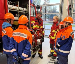 Ausbildung an der Tragkraftspritze: Marco Fischer, Jugendfeuerwehrwart der FF Rehna (Landkreis Nordwestmecklenburg), erklärt den Jugendfeuerwehrmitgliedern die Funktionsweise. Heben, Tragen und eigenmächtiges Bedienen des schweren Einsatzgerätes ist jedoch tabu. (Bild: Christian Heinz / HFUK Nord)