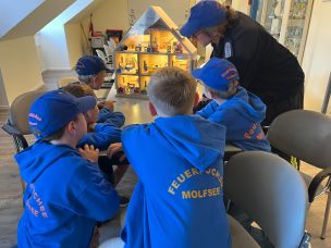In der Kinderfeuerwehr ist die Brandschutzerziehung ein wichtiger Inhalt. Die Kinder der FF Molfsee lernen hier im Rauchdemohaus das richtige Verhalten im Brandfall. (Bild: Christian Heinz / HFUK Nord)