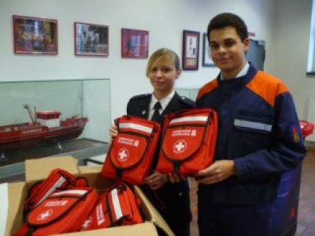 Lena Igla, Fachwartin Bildung der Hamburger Jugendfeuerwehren und Landesjugendsprecher Lionel Heilmann freuen sich über die neuen Erste-Hilfe-Rucksäcke.  