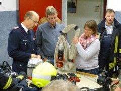 Dr. Paululat erklärt den Arbeitsmedizinern Ausrüstungsgegenstände, die die Atemschutzgeräteträger beim Innenangriff mit sich führen. 